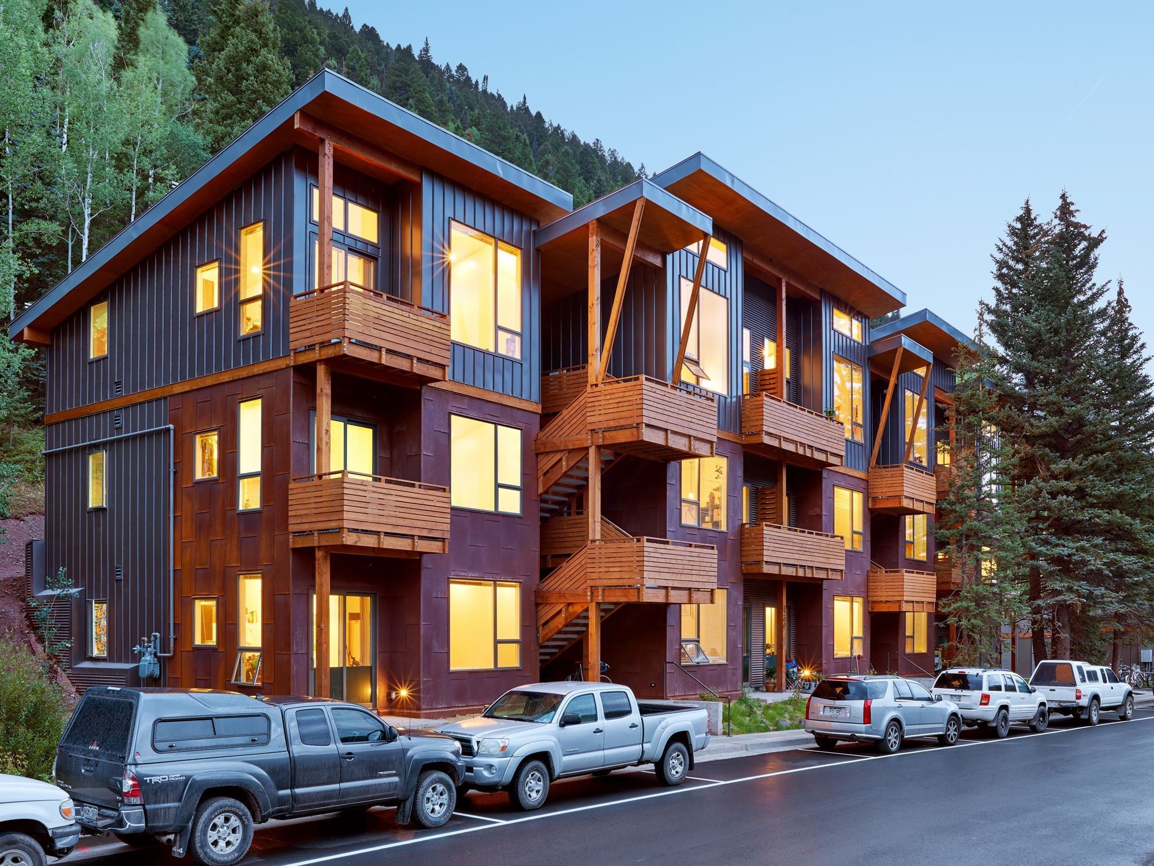 The Virginia Placer Apartment Complex has grey and maroon exteriors with wooden decks and wide windows. 
